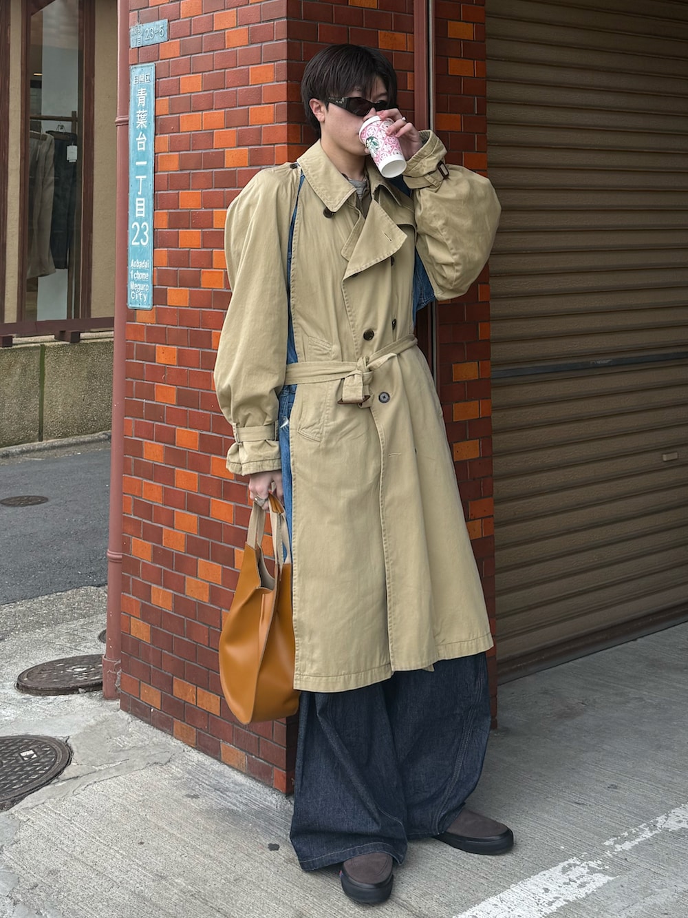 ベージュ系のトレンチコート、グリーン系のシャツ/ブラウス、グレー系のTシャツ/カットソーを着用したメンズの春コーディネートの2枚目の写真