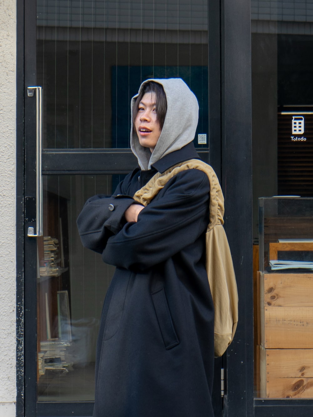 ブラック系のステンカラーコート、グレー系のスウェットパンツ、ベージュ系のショルダーバッグを着用したメンズの冬コーディネートの4枚目の写真