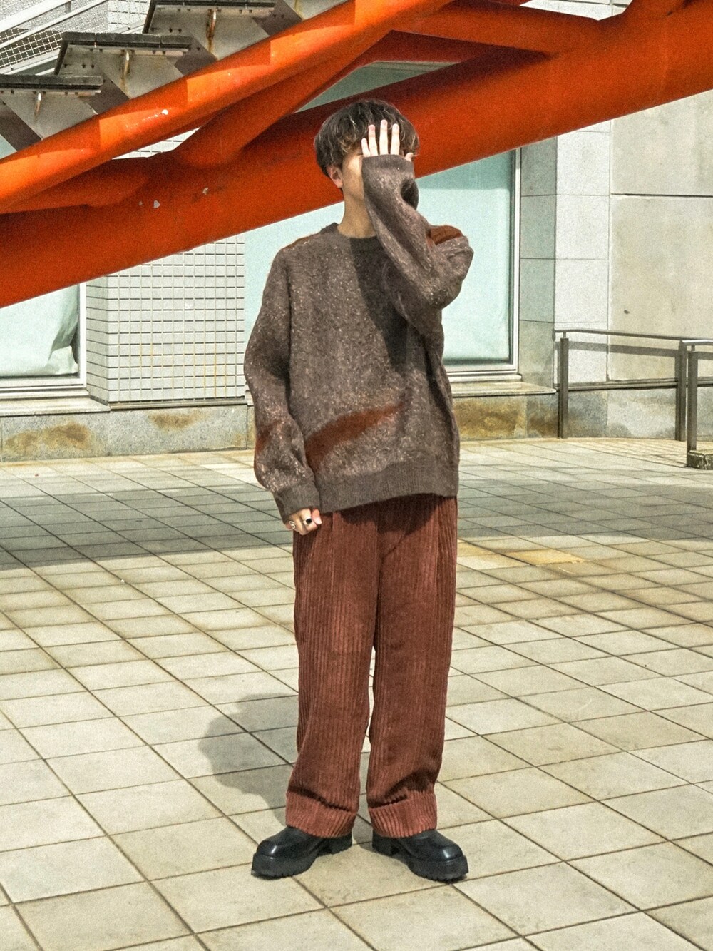 ブラウン系のニット/セーター、ブラウン系のその他パンツ、ブラック系のブーツを着用したメンズの秋コーディネートの2枚目の写真