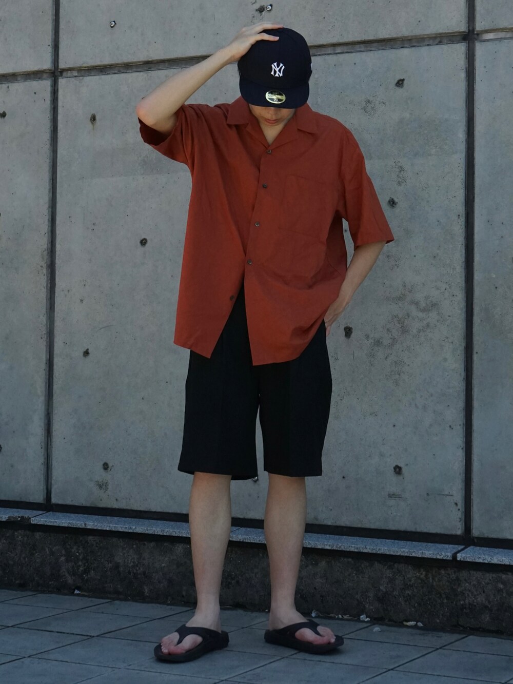 オレンジ系のシャツ/ブラウス、ブラック系のスラックス、ブラック系のサンダルを着用したメンズの夏コーディネートの4枚目の写真