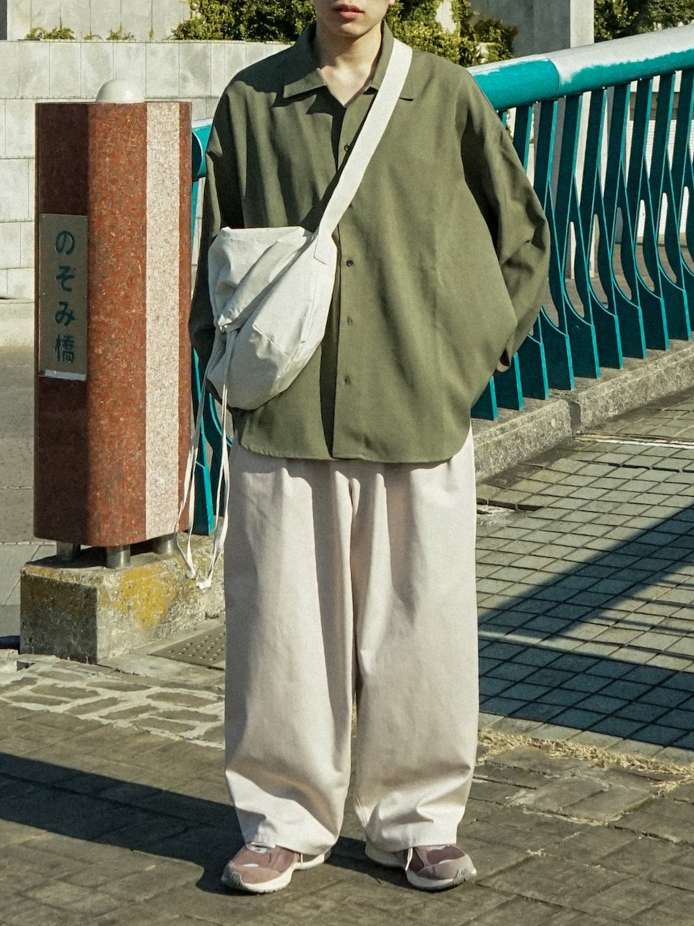 グリーン系のシャツ/ブラウス、ベージュ系のその他パンツ、ブラウン系のスニーカーを着用したメンズの春コーディネートの5枚目の写真