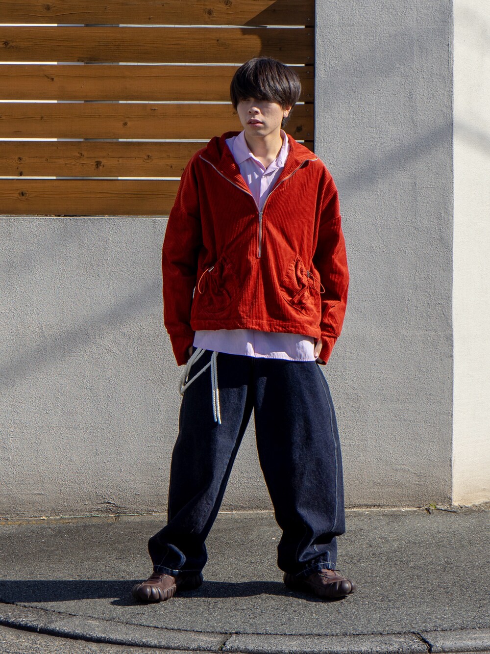 オレンジ系のブルゾン、ピンク系のシャツ/ブラウス、ブルー系のデニムパンツを着用したメンズの秋コーディネートの2枚目の写真