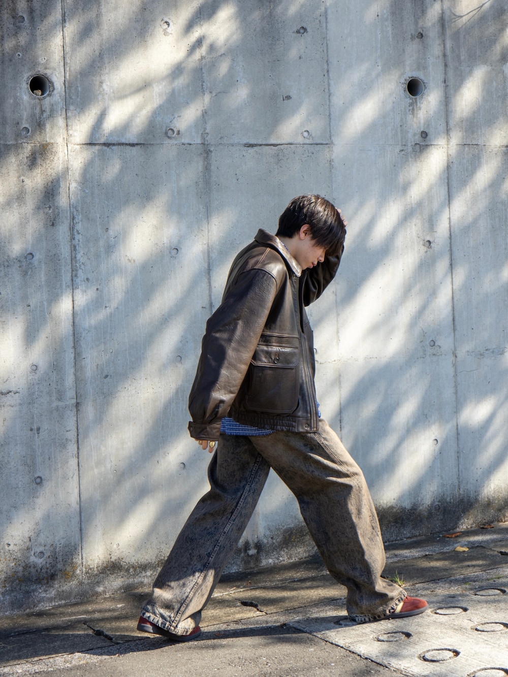 ブラウン系のブルゾン、ブルー系のデニムパンツ、ブルー系のシャツ/ブラウスを着用したメンズの秋コーディネートの4枚目の写真