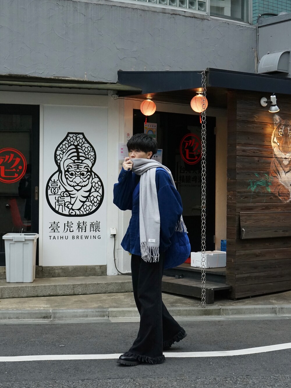 ブルー系のテーラードジャケット、ブラック系のデニムパンツ、ブルー系のショルダーバッグを着用したメンズの冬コーディネートの4枚目の写真