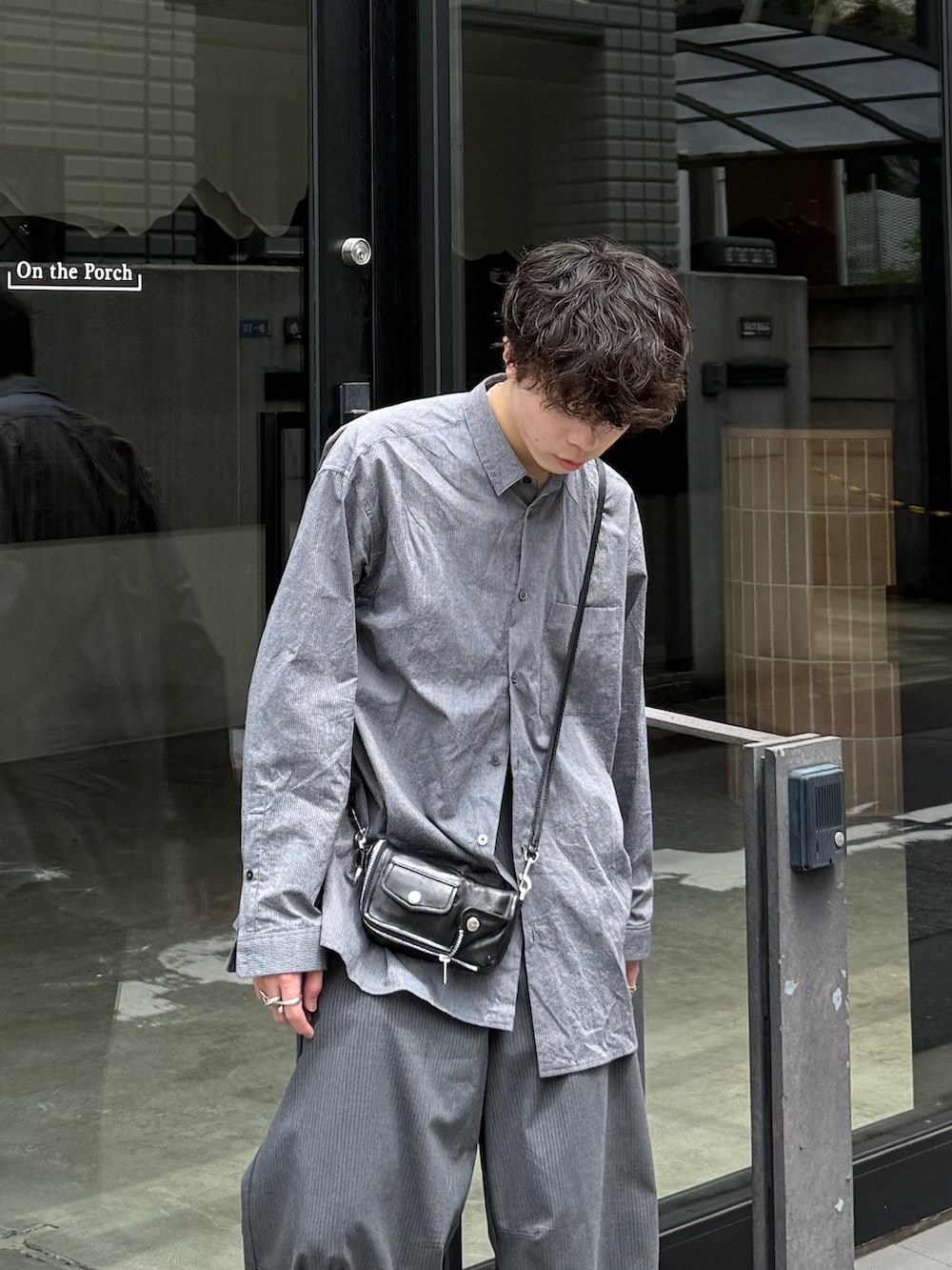 ブルー系のシャツ/ブラウス、グレー系のスラックス、ブラウン系のスニーカーを着用したメンズの夏コーディネートの2枚目の写真