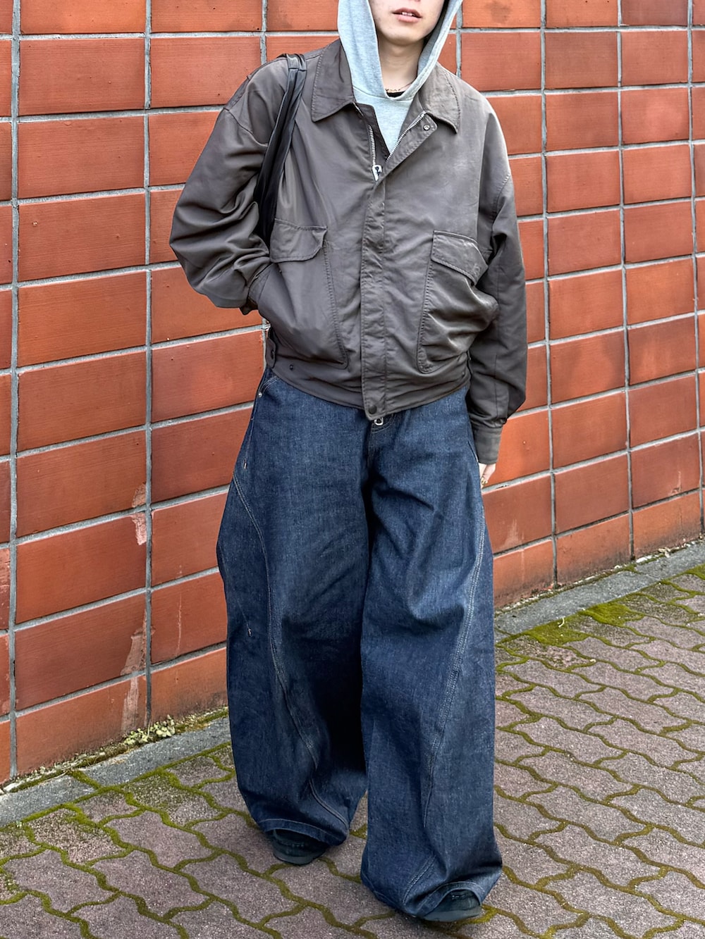 ブルー系のデニムパンツ、ブラック系のその他シューズ、グレー系のナイロンジャケットを着用したメンズの春コーディネートの5枚目の写真