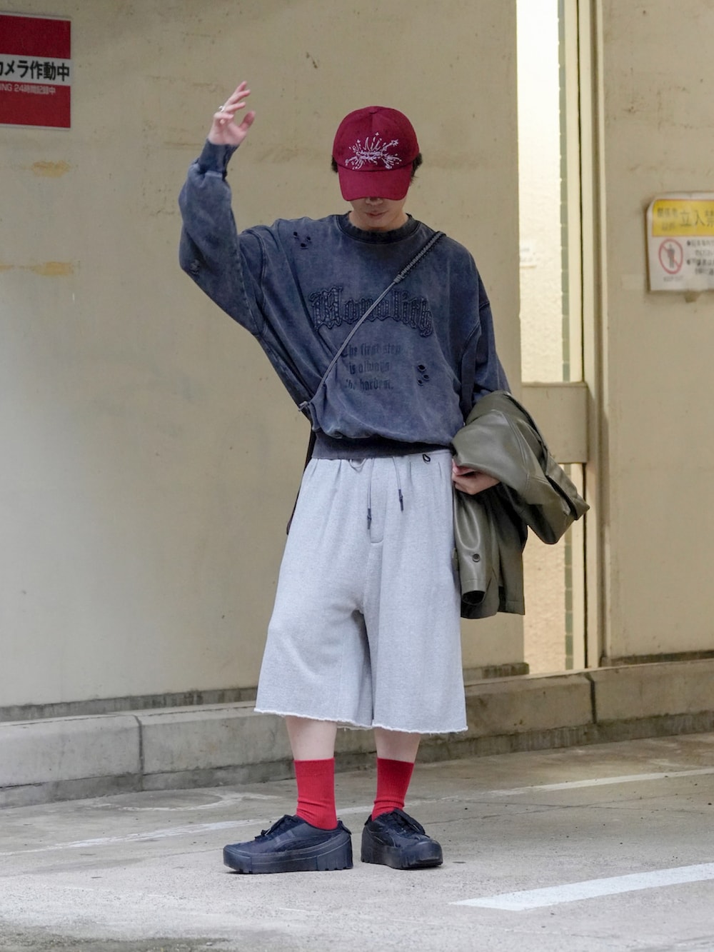 グレー系のスウェット、ブラック系のカバーオール、ブラウン系のショルダーバッグを着用したメンズの秋コーディネートの2枚目の写真