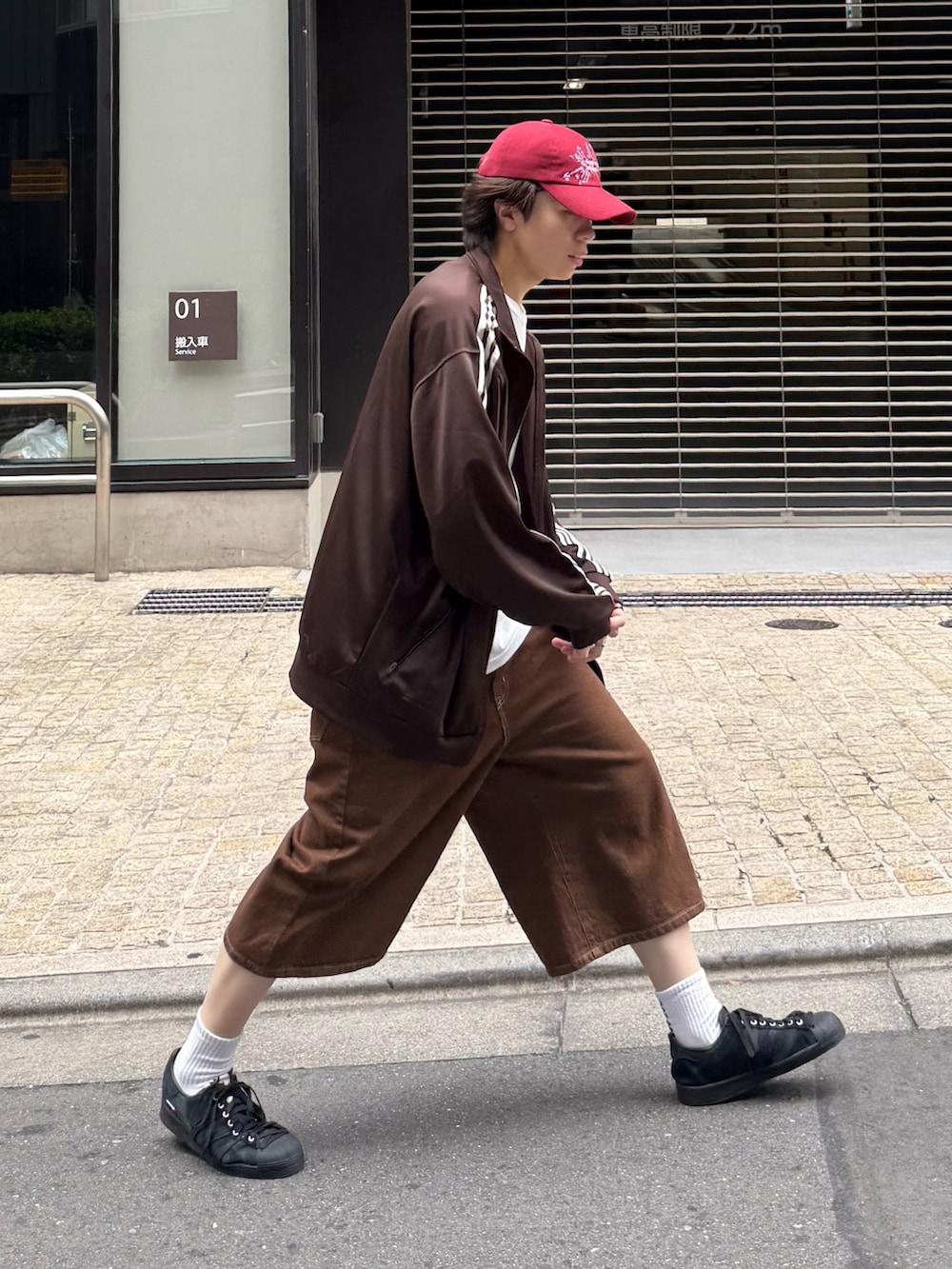 ブラウン系のジャージ、ホワイト系のTシャツ/カットソー、ブラウン系のデニムパンツを着用したメンズの春コーディネートの2枚目の写真