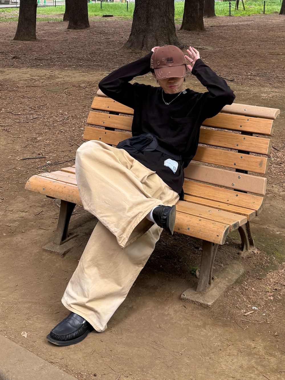 ブラック系のTシャツ/カットソー、ベージュ系のチノパンツ、ブラック系のボディバッグ/ウエストポーチを着用したメンズの春コーディネートの2枚目の写真