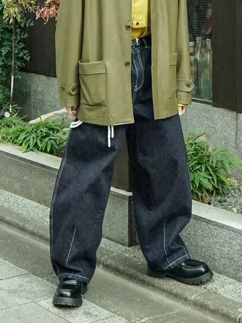 グリーン系のカバーオール、イエロー系のシャツ/ブラウス、ブルー系のデニムパンツを着用したメンズの冬コーディネートの4枚目の写真