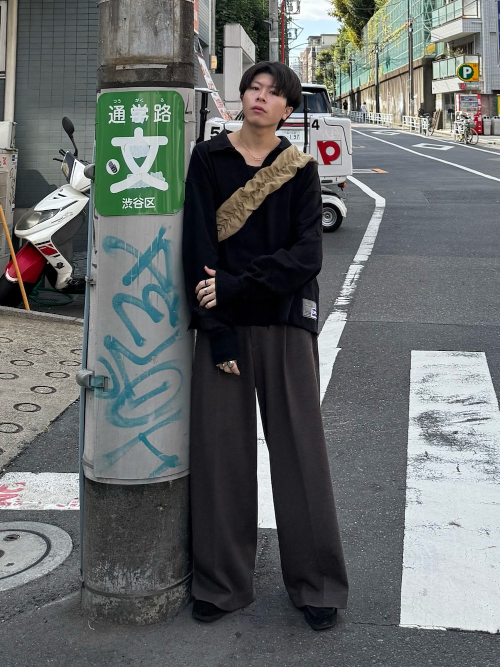 ブラック系のスウェット、ブラウン系のスラックス、ベージュ系のショルダーバッグを着用したメンズの秋コーディネートの2枚目の写真