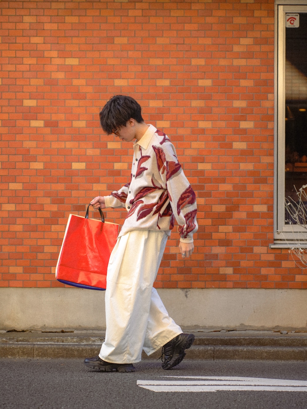 ホワイト系のカーディガン/ボレロ、ホワイト系のチノパンツ、ホワイト系のトートバッグを着用したメンズの春コーディネートの3枚目の写真