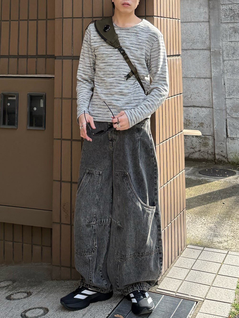 グレー系のTシャツ/カットソー、グレー系のデニムパンツ、グリーン系のバックパック/リュックを着用したメンズの春コーディネートの3枚目の写真