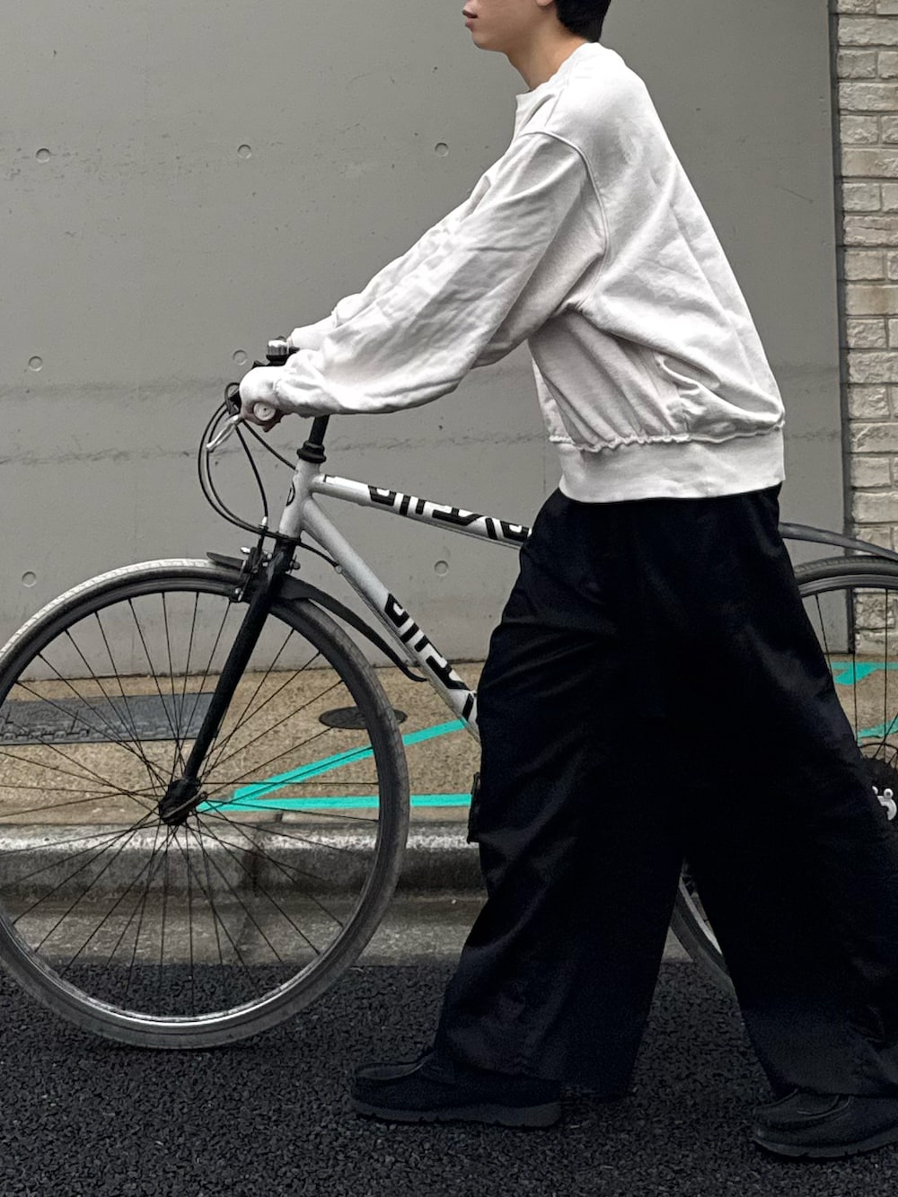 ホワイト系のスウェット、ブラック系のその他パンツ、ブラック系のモカシン/デッキシューズを着用したメンズの春コーディネートの3枚目の写真