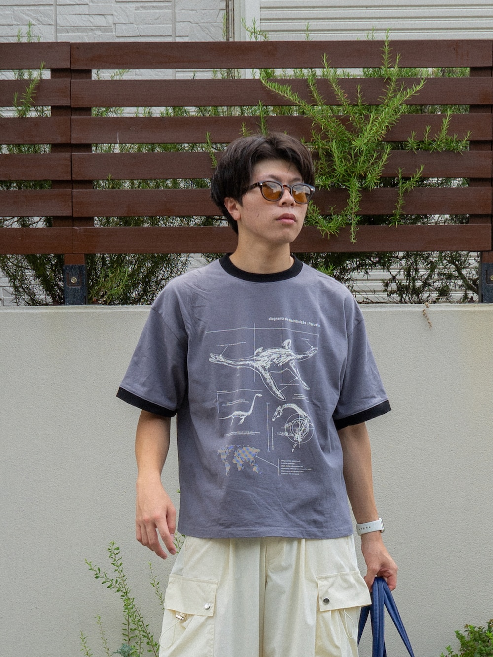 グレー系のTシャツ/カットソー、ブルー系のボストンバッグ、ホワイト系のカーゴパンツを着用したメンズの夏コーディネートの3枚目の写真