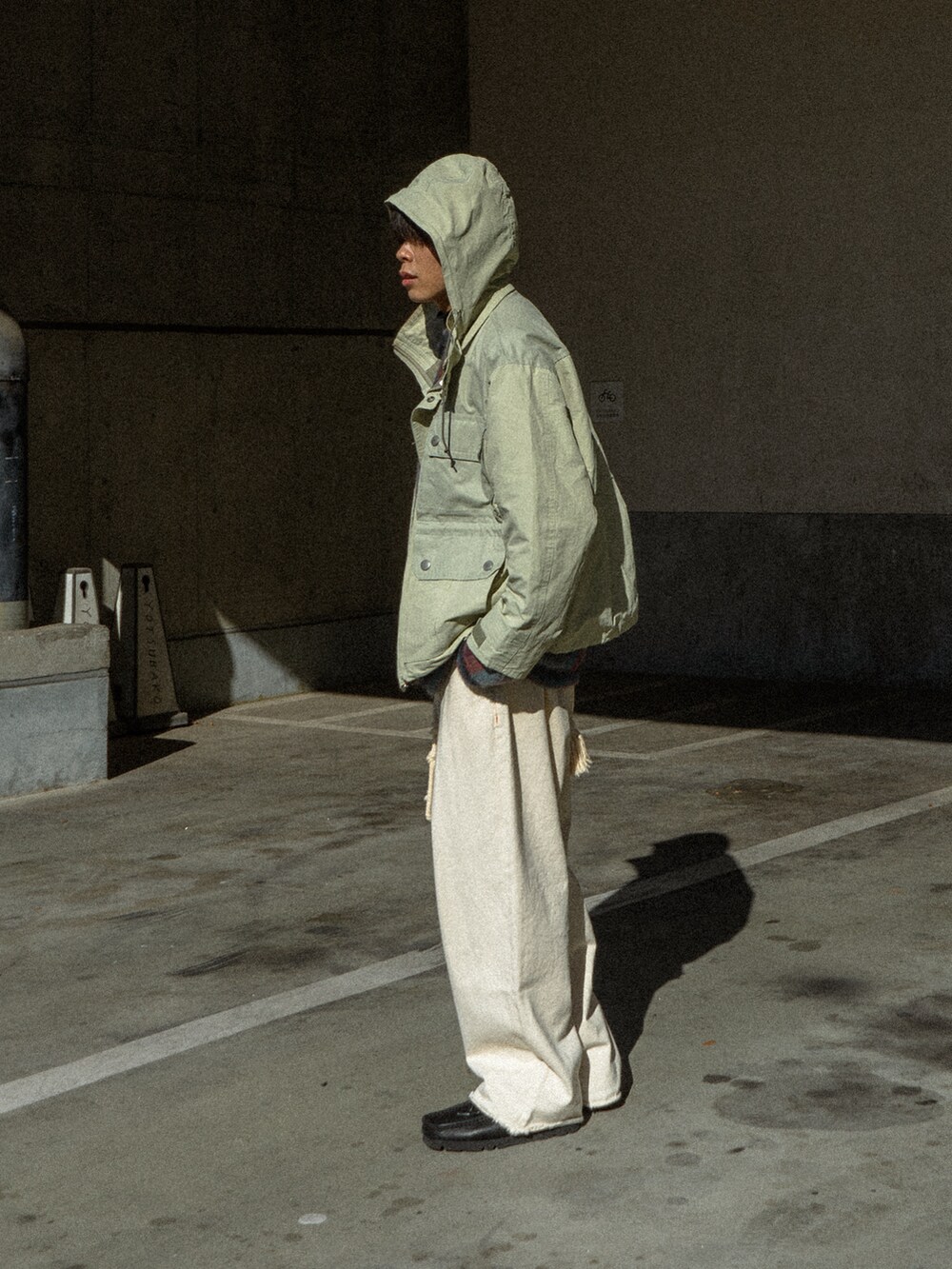 ベージュ系のマウンテンパーカー、ブラック系のデニムパンツ、ブラック系のブーツを着用したメンズの冬コーディネートの2枚目の写真