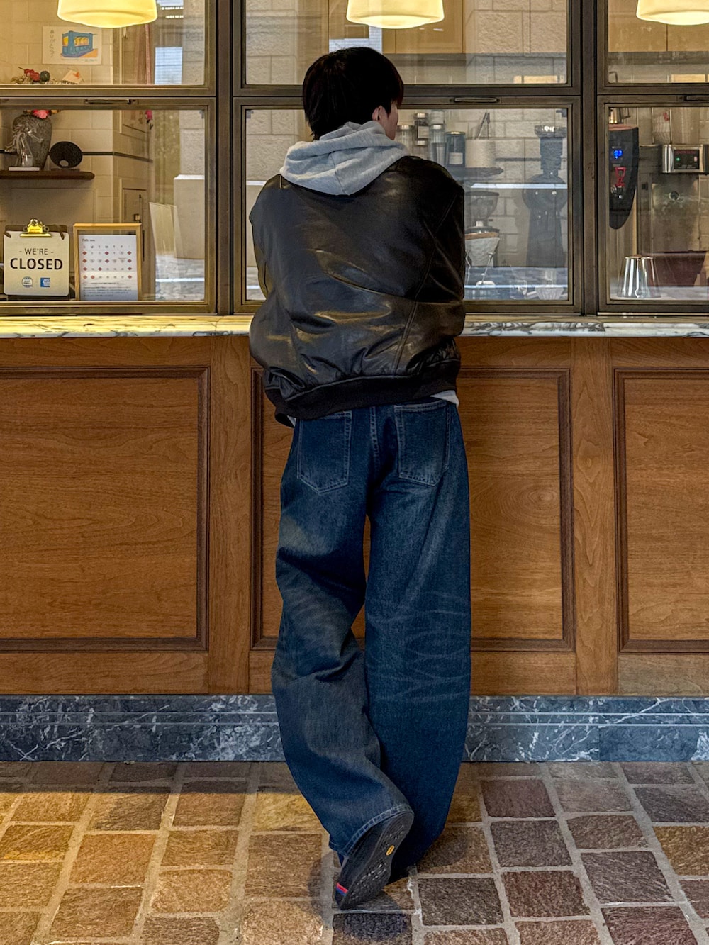 ブラウン系のMA-1、ブルー系のデニムパンツ、グレー系のパーカーを着用したメンズの冬コーディネートの2枚目の写真