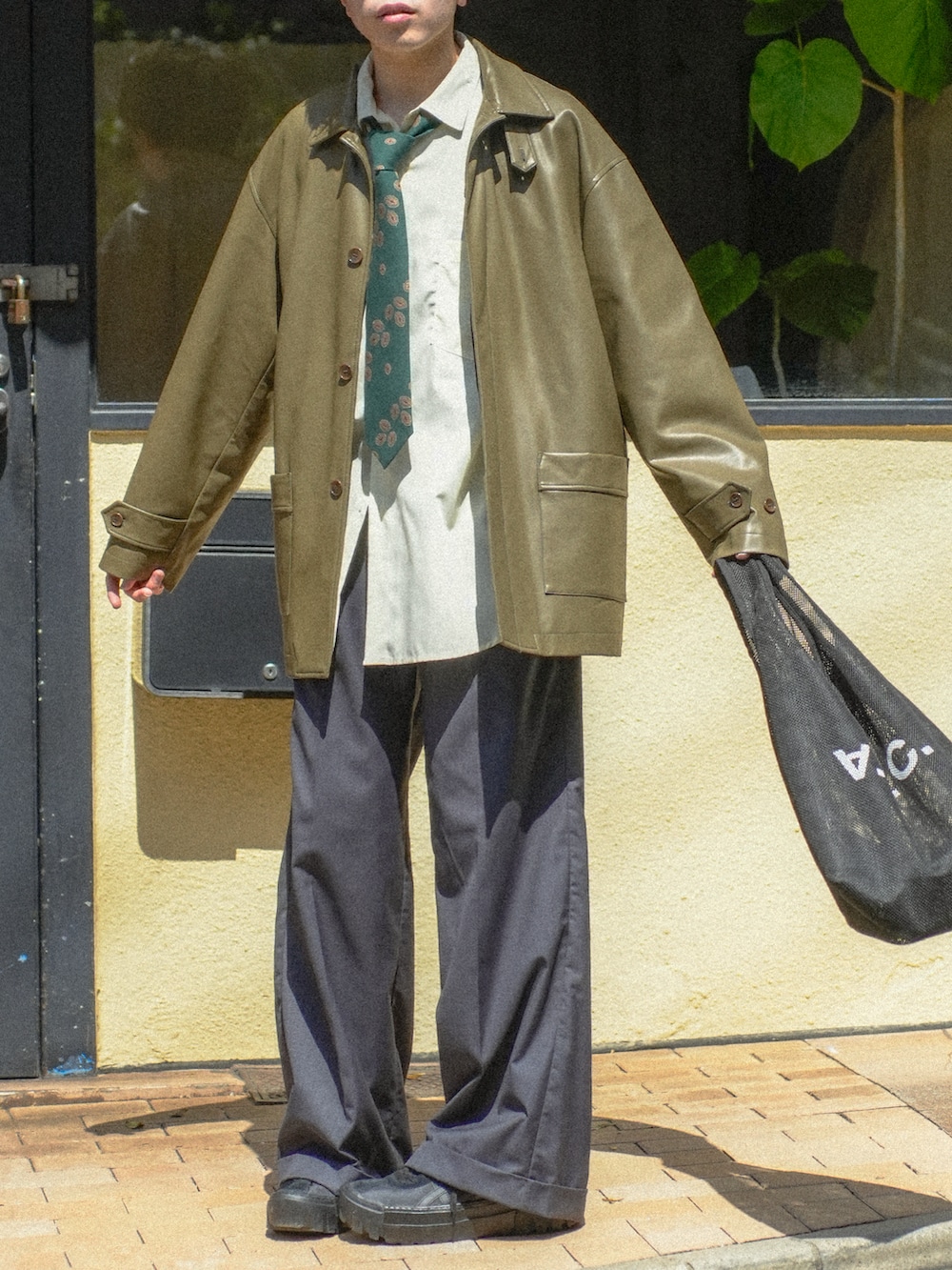 ブラック系のカバーオール、イエロー系のシャツ/ブラウス、グレー系のスラックスを着用したメンズの春コーディネートの5枚目の写真