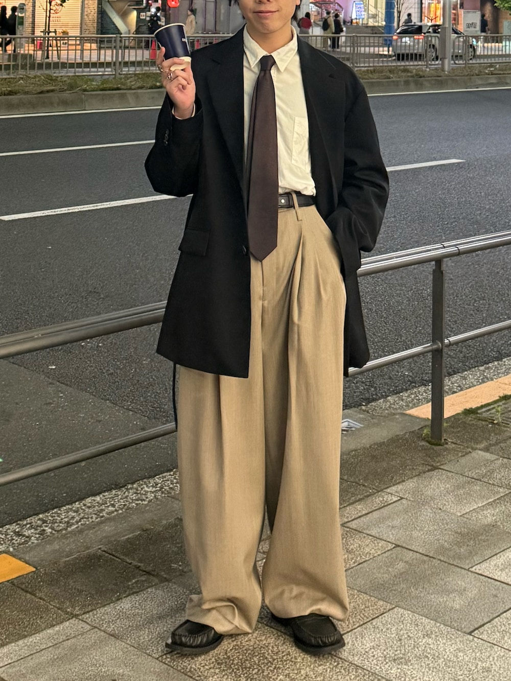 ブラック系のテーラードジャケット、ホワイト系のシャツ/ブラウス、ベージュ系のスラックスを着用したメンズの春コーディネートの4枚目の写真