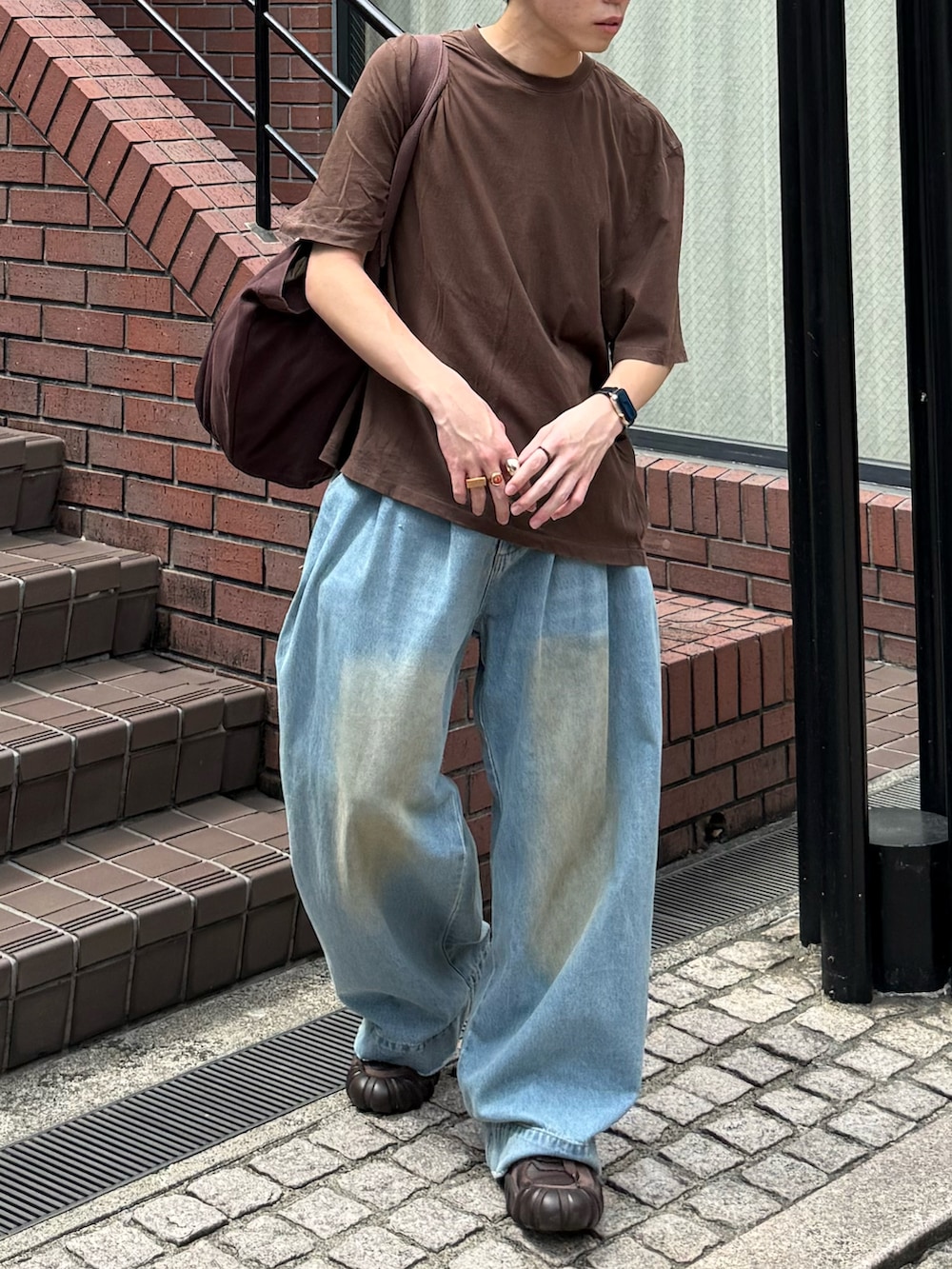 ブラウン系のTシャツ/カットソー、ブルー系のデニムパンツ、ブラウン系のトートバッグを着用したメンズの夏コーディネートの4枚目の写真