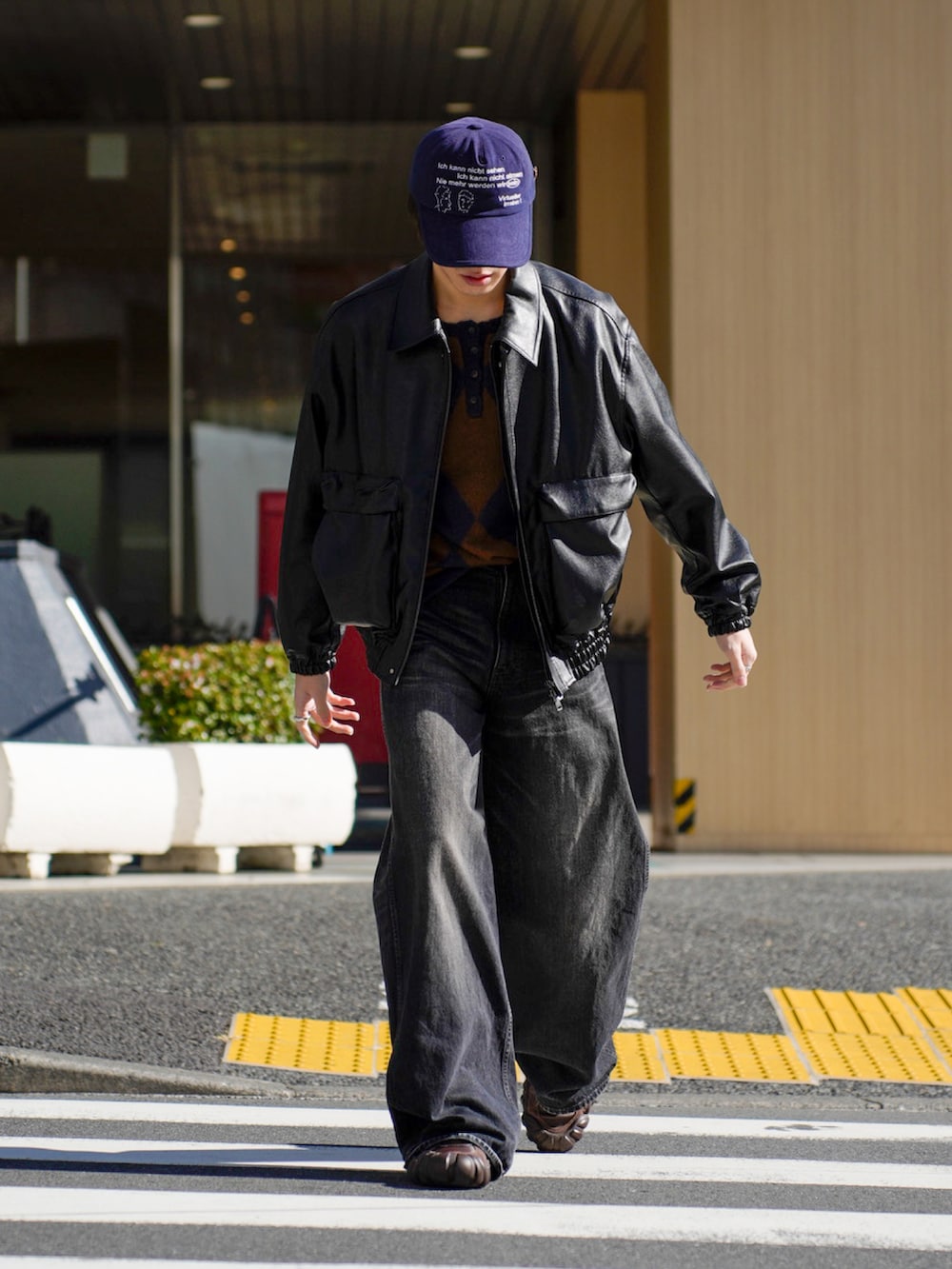 ブラック系のブルゾン、ブラック系のデニムパンツ、ブラウン系のスニーカーを着用したメンズの秋コーディネートの2枚目の写真