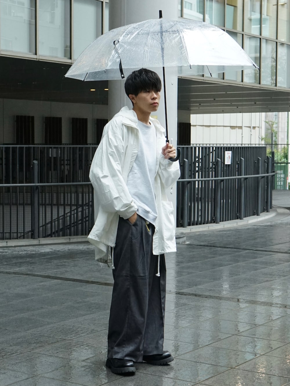 ホワイト系のマウンテンパーカー、グレー系のスウェット、グレー系のスラックスを着用したメンズの秋コーディネートの3枚目の写真