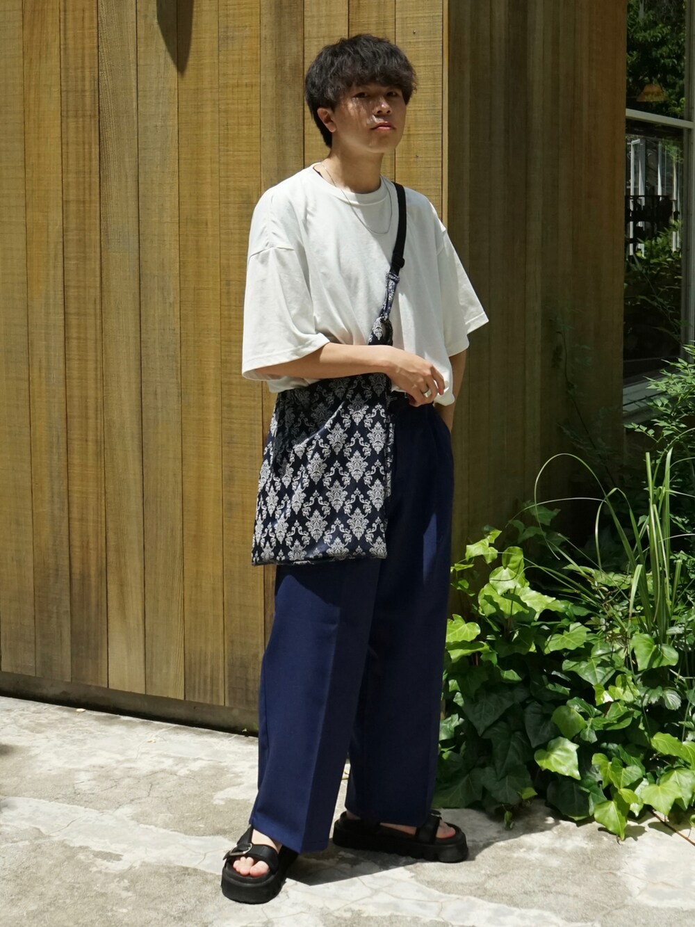 ホワイト系のTシャツ/カットソー、ブルー系のスラックス、ブルー系のショルダーバッグを着用したメンズの夏コーディネートの2枚目の写真