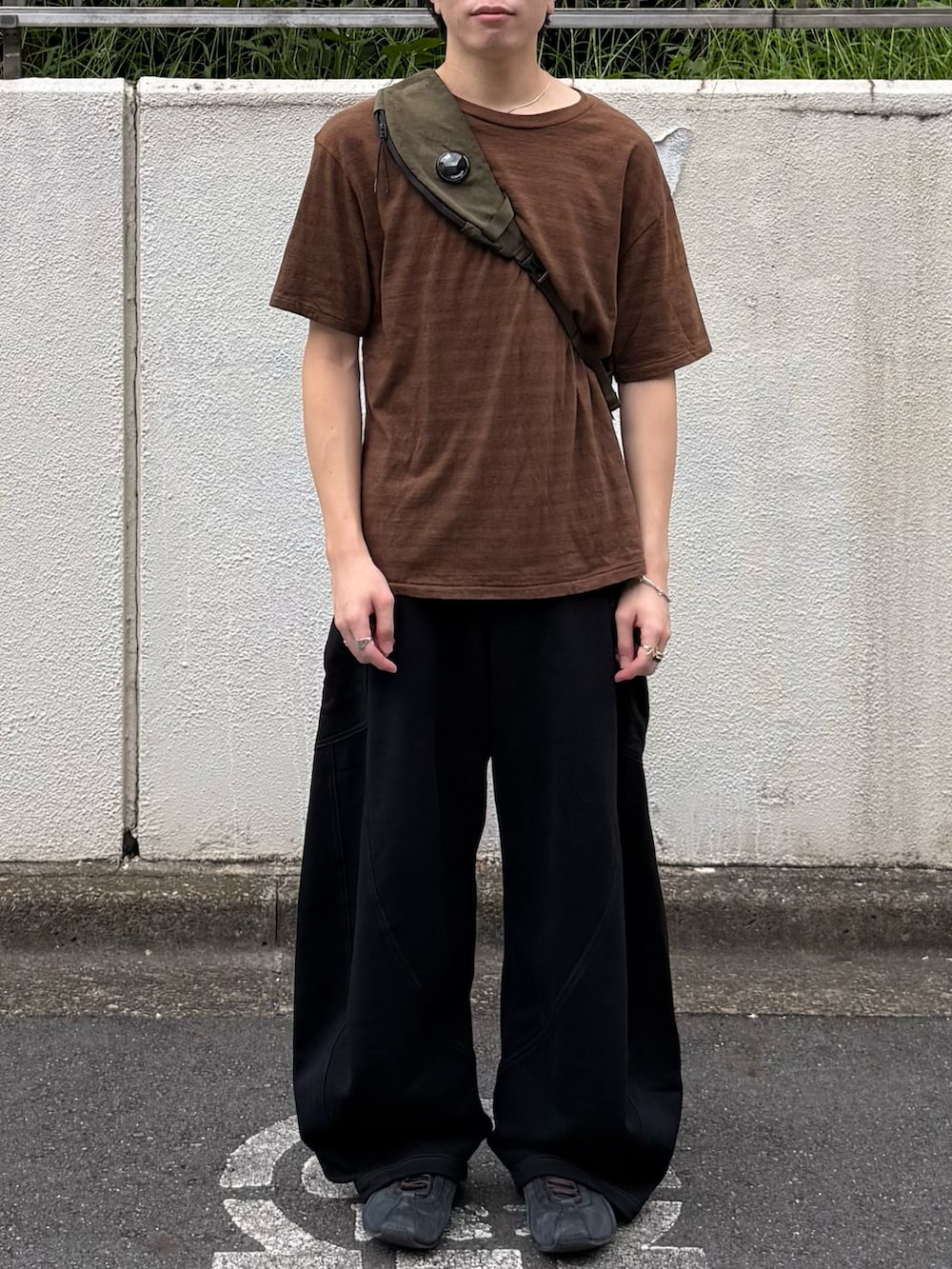 ブラウン系のTシャツ/カットソー、ブラック系のスウェットパンツ、グリーン系のバックパック/リュックを着用したメンズの夏コーディネートの4枚目の写真