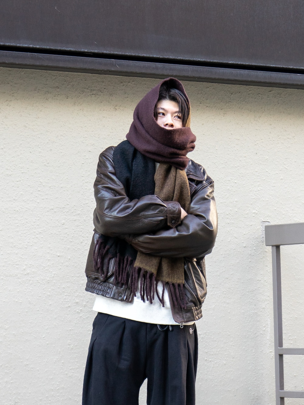 ブラウン系のブルゾン、ブラック系のスウェットパンツ、ブラウン系のスニーカーを着用したメンズの冬コーディネートの4枚目の写真