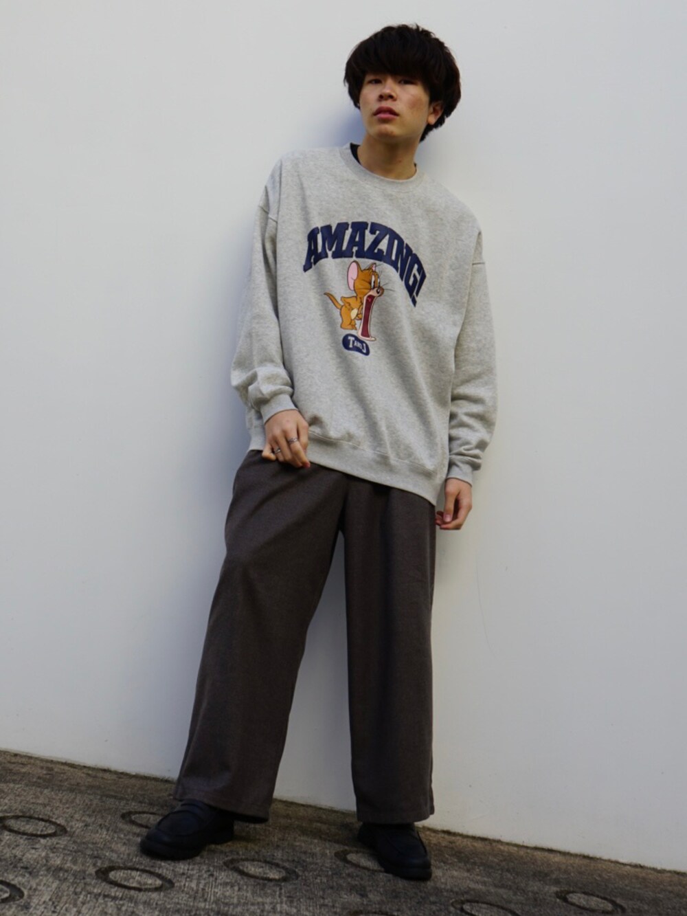 グレー系のスウェット、ベージュ系のスラックス、ブラック系のローファーを着用したメンズの冬コーディネートの2枚目の写真