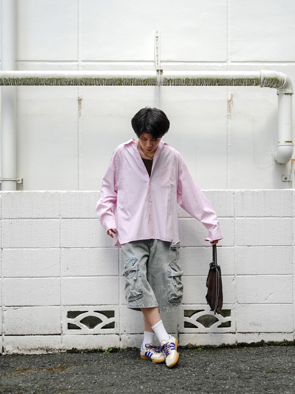 ピンク系のシャツ/ブラウス、ブルー系のデニムパンツ、ブラウン系のショルダーバッグを着用したメンズの秋コーディネートの2枚目の写真