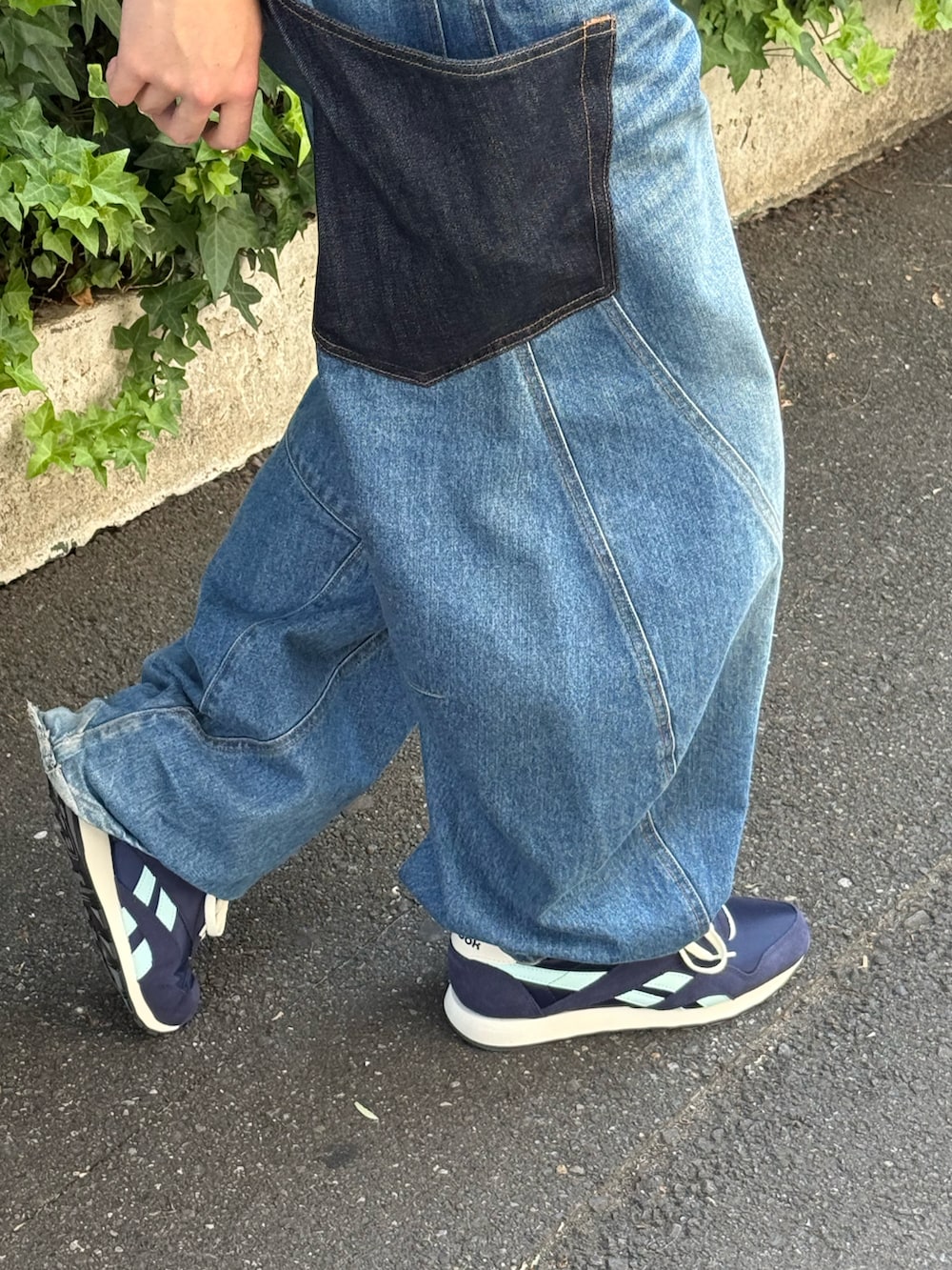 ブルー系のデニムパンツ、ブラック系のデジタル腕時計、レッド系のキャップを着用したメンズの夏コーディネートの4枚目の写真