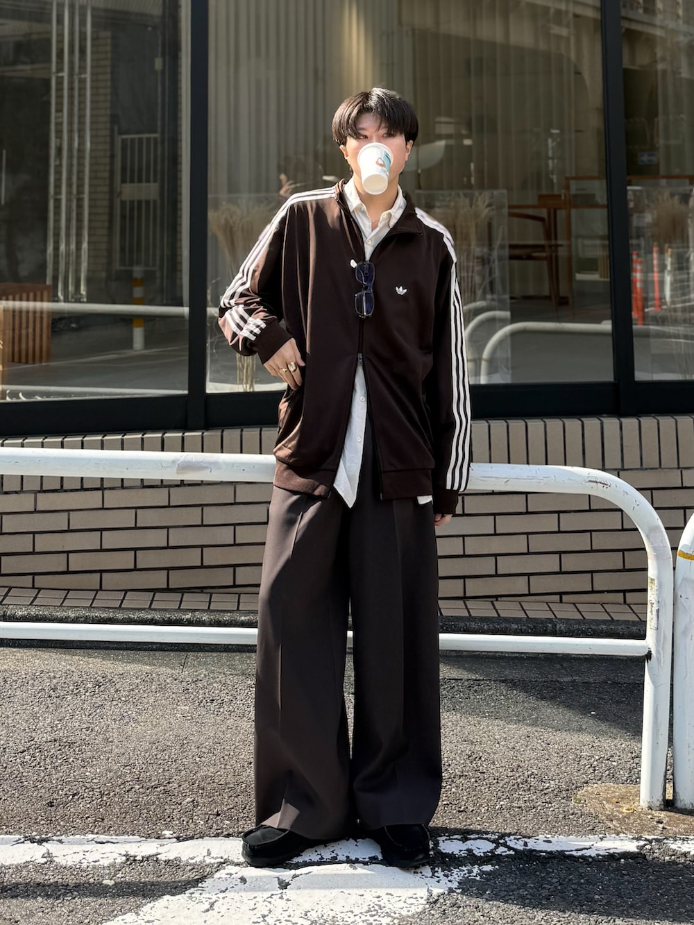 ブラウン系のジャージ、ブラック系のモカシン/デッキシューズ、ブラウン系のサングラスを着用したメンズの秋コーディネートの2枚目の写真