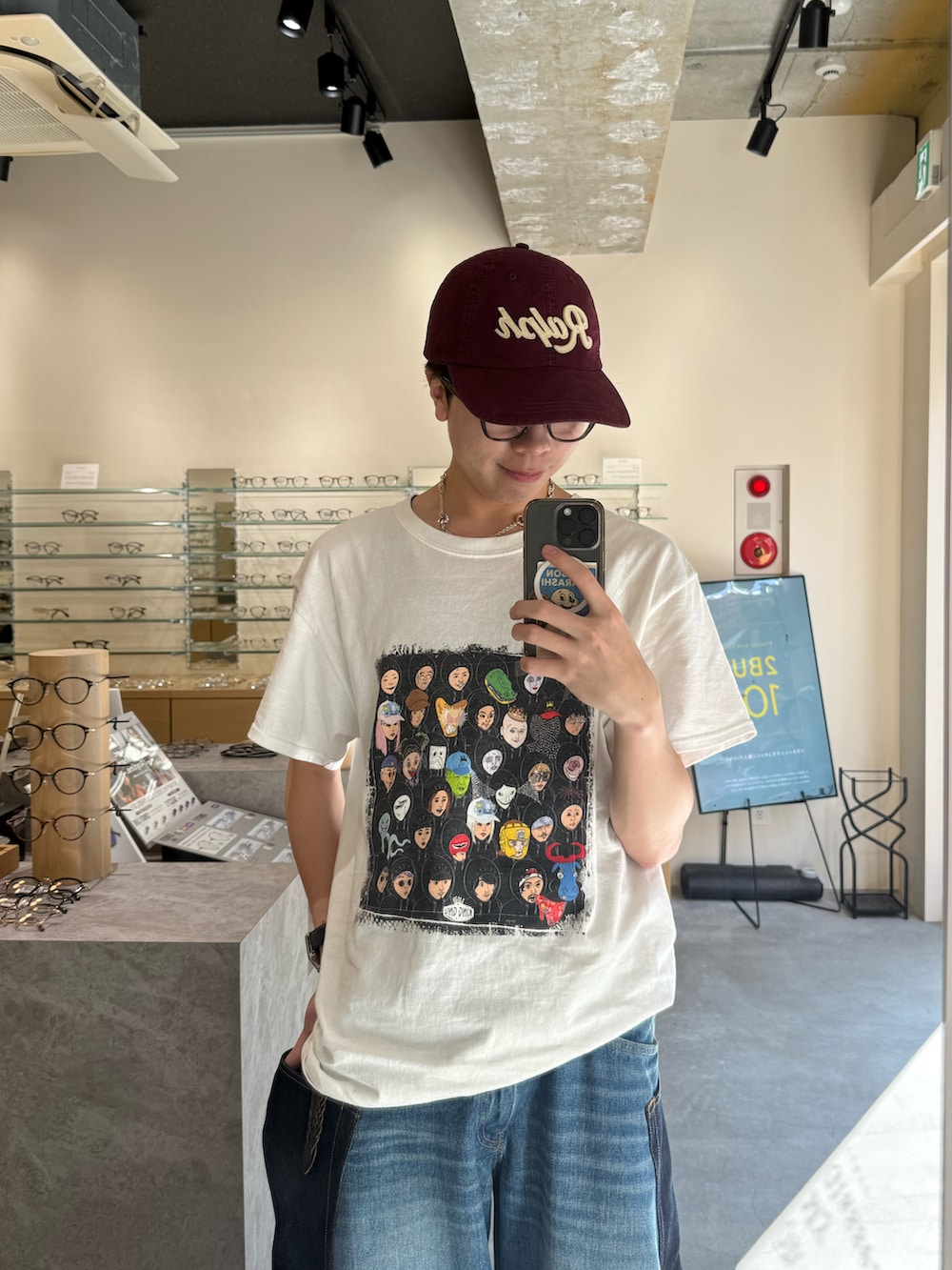 ブルー系のデニムパンツ、ブラック系のデジタル腕時計、レッド系のキャップを着用したメンズの夏コーディネートの3枚目の写真