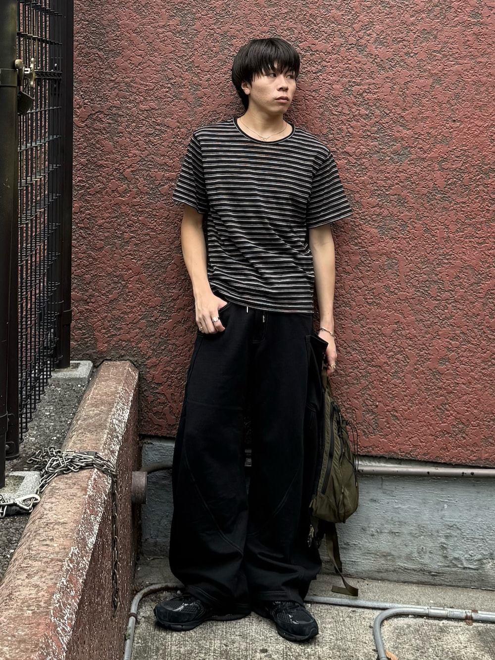 グリーン系のバックパック/リュック、ブラック系のTシャツ/カットソー、ブラック系のスウェットパンツを着用したメンズの秋コーディネートの2枚目の写真