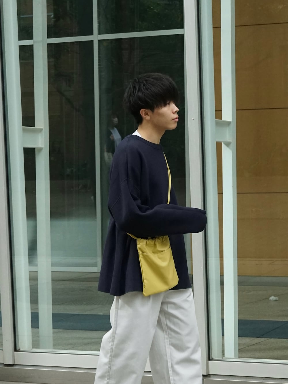 グリーン系のニット/セーター、ホワイト系のチノパンツ、イエロー系のショルダーバッグを着用したメンズの秋コーディネートの4枚目の写真