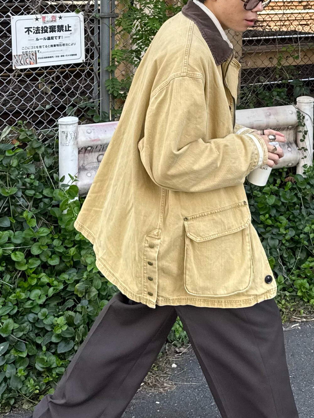 ブラック系のモカシン/デッキシューズ、イエロー系のデニムジャケット、ブラウン系のサングラスを着用したメンズの秋コーディネートの4枚目の写真