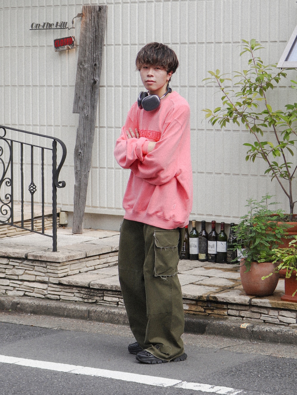 ピンク系のスウェット、グリーン系のカーゴパンツ、ブラック系のスニーカーを着用したメンズの秋コーディネートの2枚目の写真