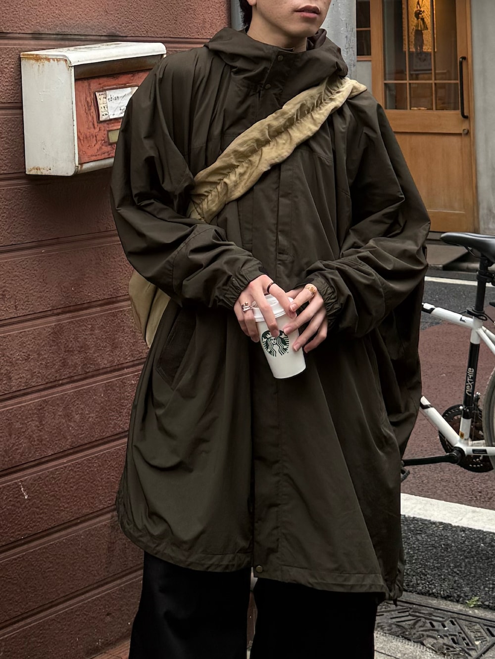 ブラック系のモカシン/デッキシューズ、ブラック系のその他パンツ、ベージュ系のショルダーバッグを着用したメンズの春コーディネートの2枚目の写真