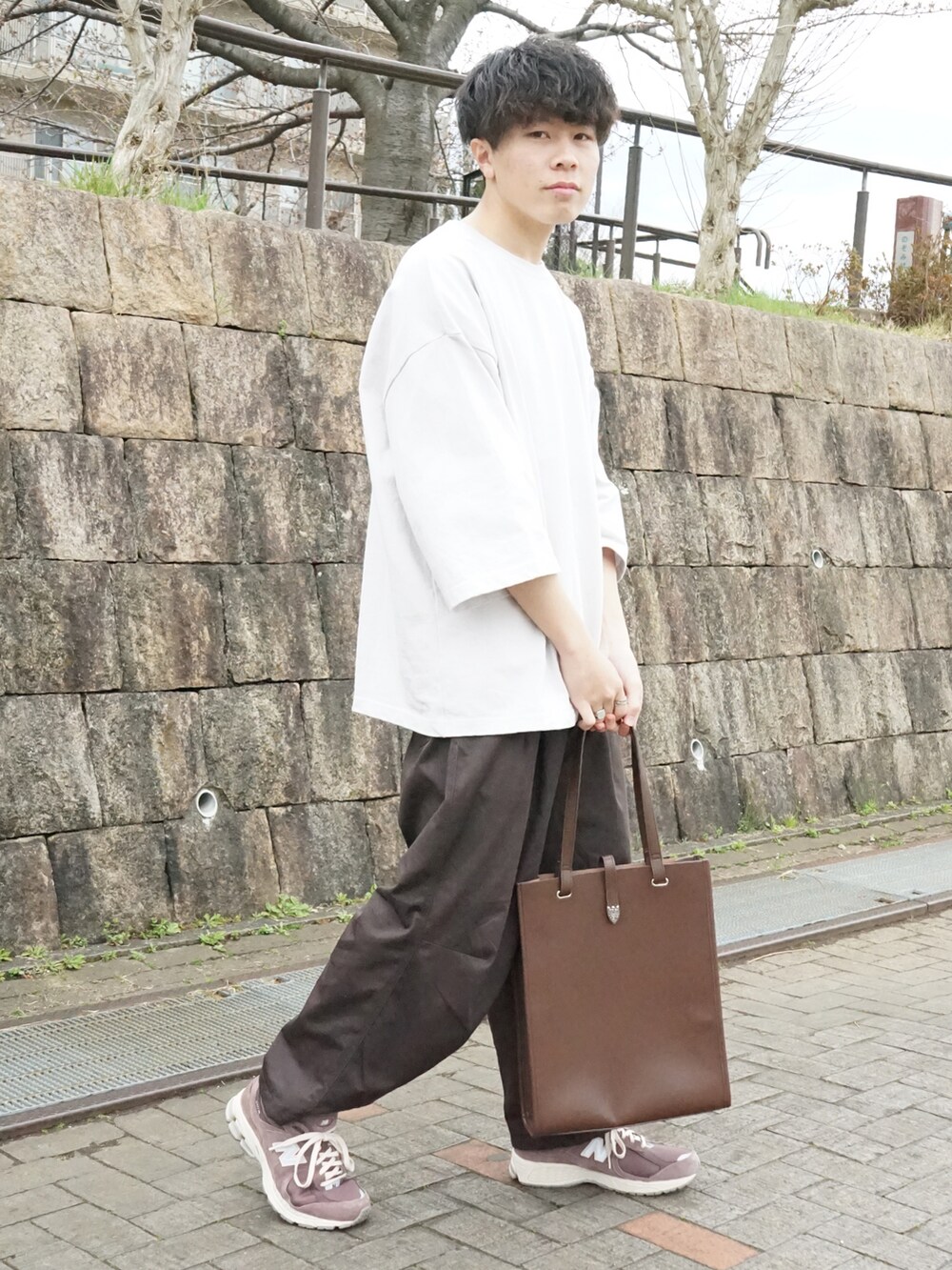 グレー系のTシャツ/カットソー、ブラウン系のカーゴパンツ、ブラウン系のトートバッグを着用したメンズの春コーディネートの2枚目の写真