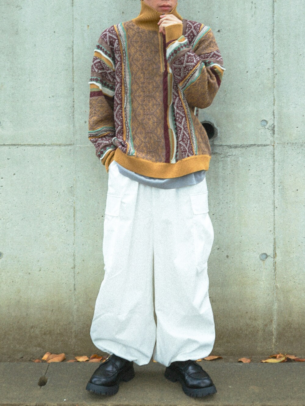 イエロー系のニット/セーター、ホワイト系のカーゴパンツ、ブラック系のローファーを着用したメンズの秋コーディネートの2枚目の写真