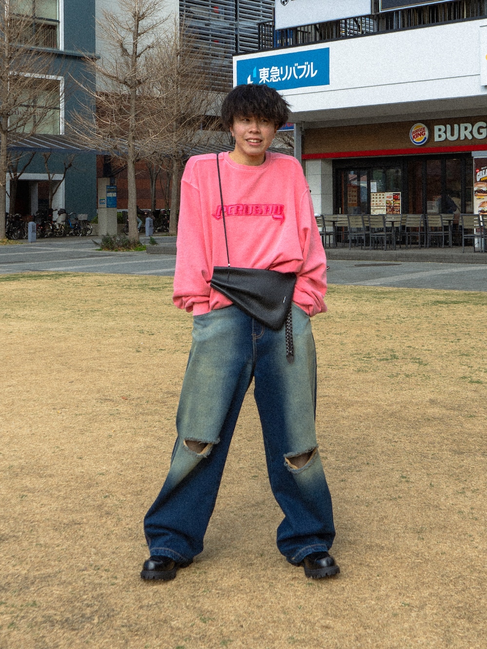 ピンク系のスウェット、ブルー系のデニムパンツ、ブラック系のショルダーバッグを着用したメンズの冬コーディネートの2枚目の写真