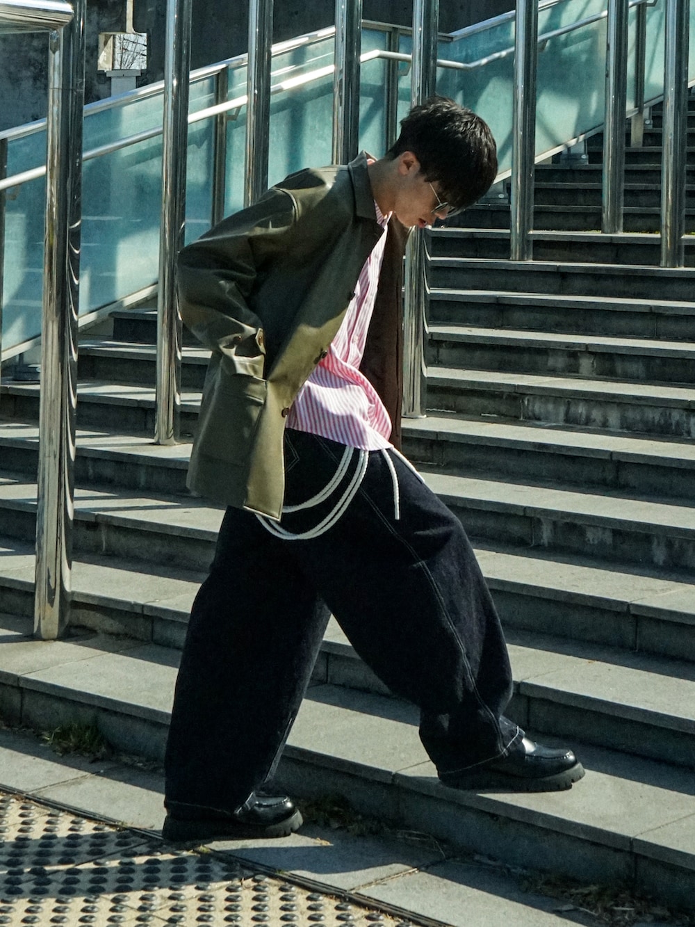 グリーン系のカバーオール、レッド系のシャツ/ブラウス、ブルー系のデニムパンツを着用したメンズの春コーディネートの2枚目の写真