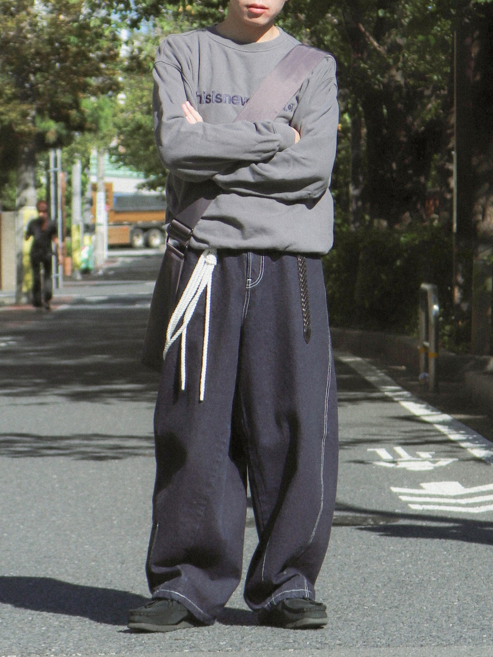 ブルー系のデニムパンツ、グレー系のショルダーバッグ、ブラック系のその他シューズを着用したメンズの秋コーディネートの5枚目の写真