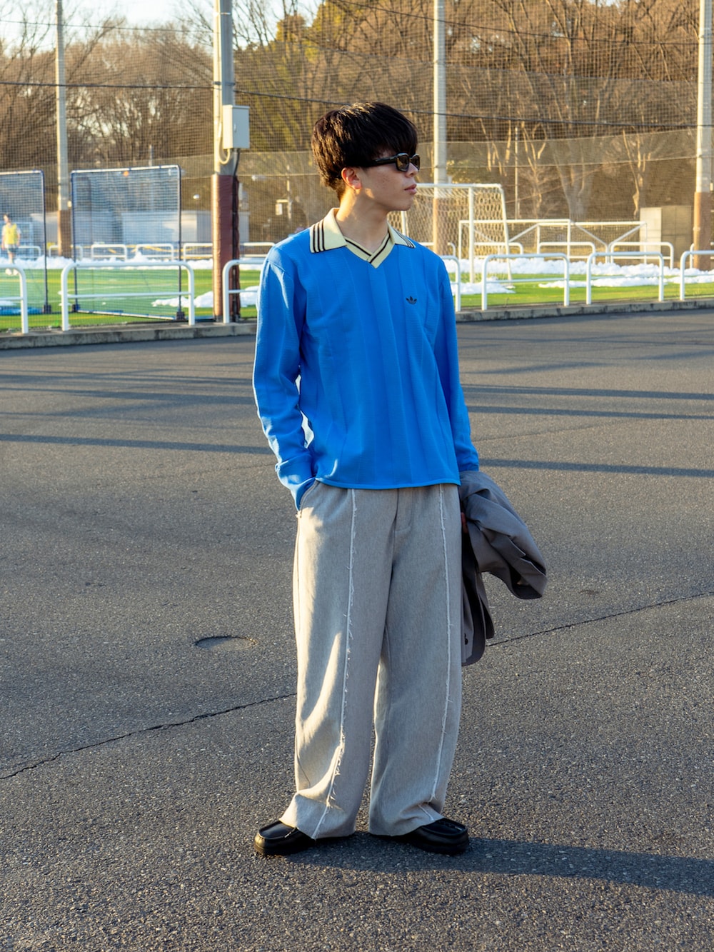 ブルー系のニット/セーター、グレー系のスウェットパンツ、ブラック系のブーツを着用したメンズの冬コーディネートの2枚目の写真