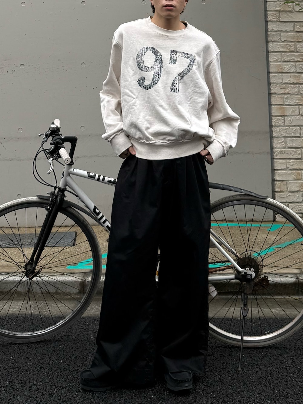 ホワイト系のスウェット、ブラック系のその他パンツ、ブラック系のモカシン/デッキシューズを着用したメンズの春コーディネートの4枚目の写真