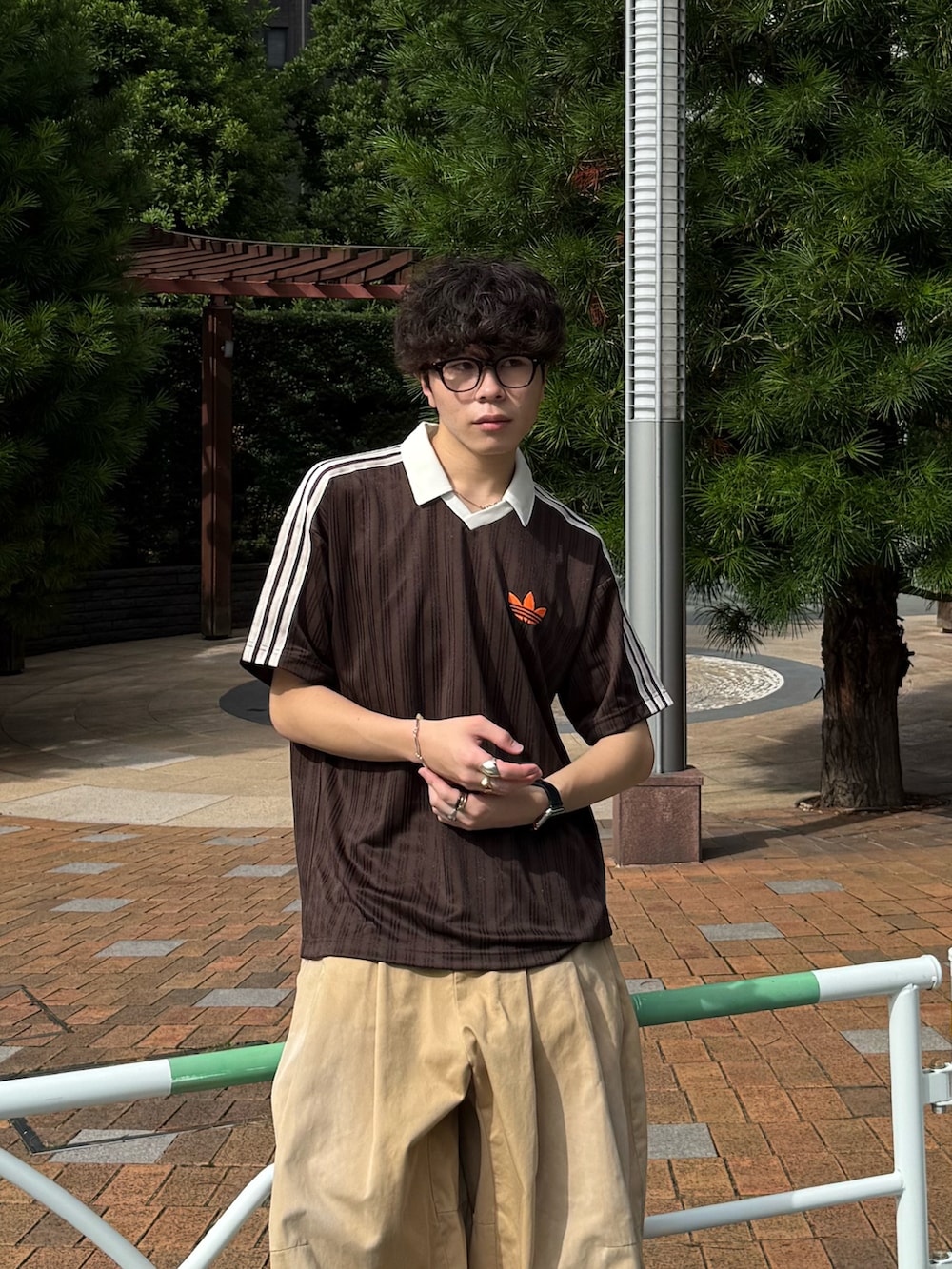 ブラウン系のTシャツ/カットソー、ベージュ系のチノパンツ、ブラウン系のスニーカーを着用したメンズの夏コーディネートの3枚目の写真