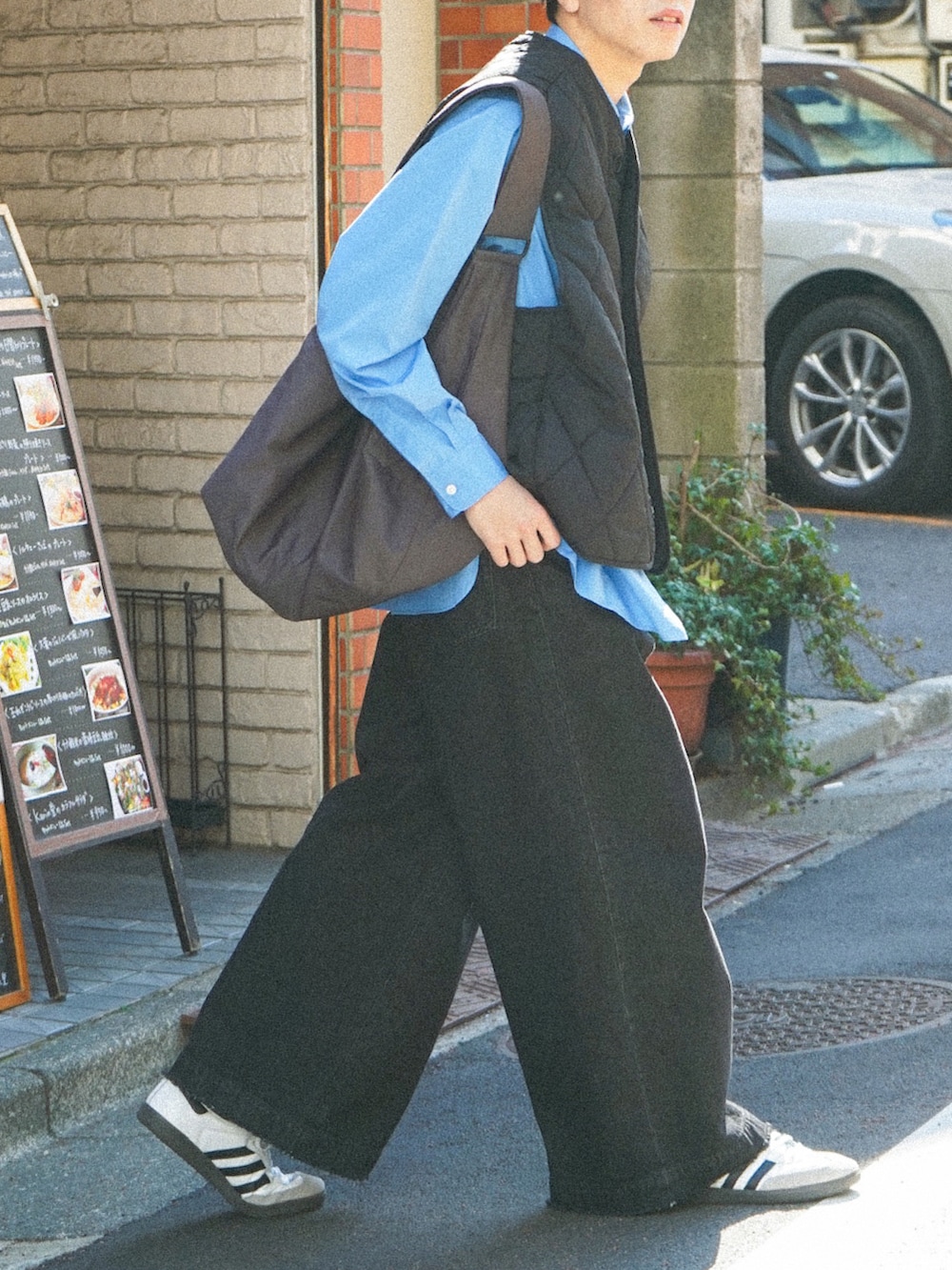 ブラック系のベスト、ブルー系のシャツ/ブラウス、ブラック系のデニムパンツを着用したメンズの春コーディネートの5枚目の写真