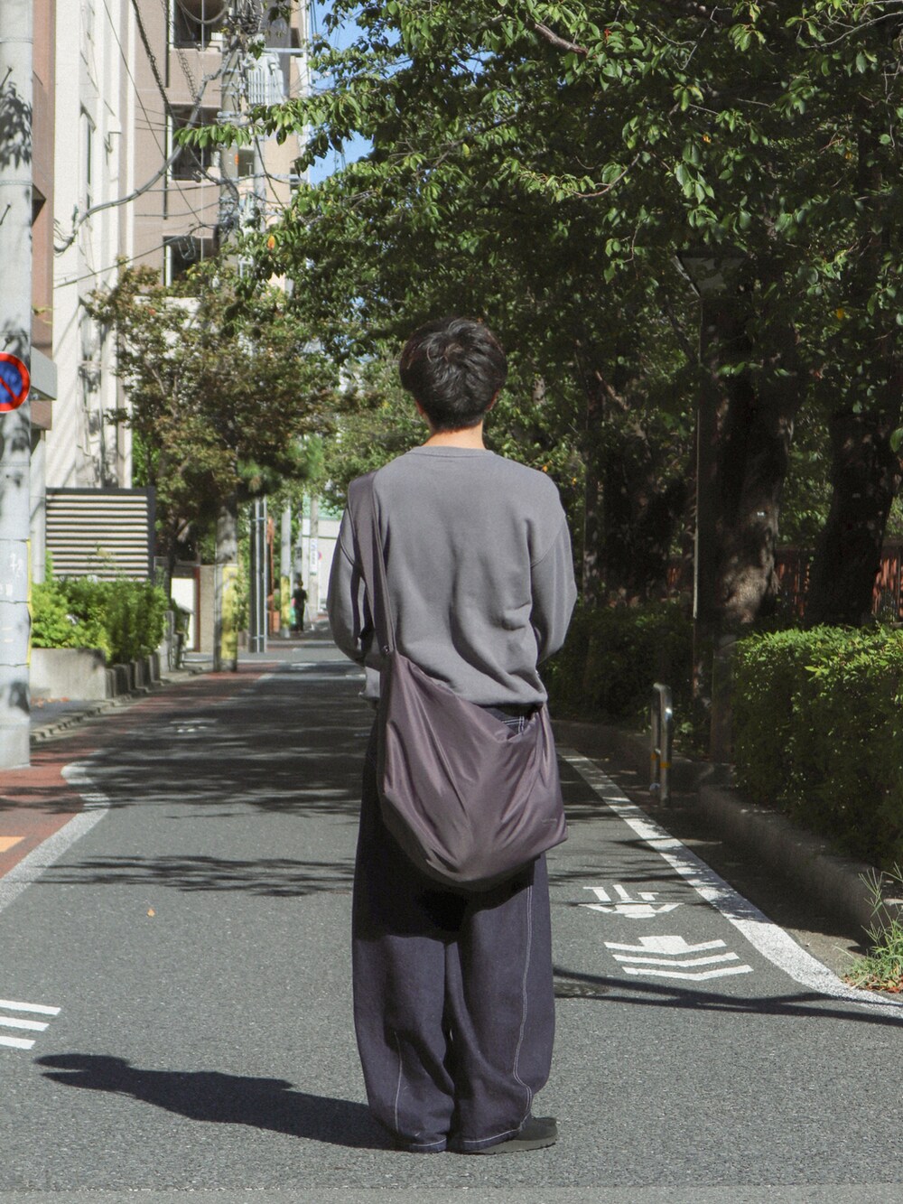 ブルー系のデニムパンツ、グレー系のショルダーバッグ、ブラック系のその他シューズを着用したメンズの秋コーディネートの3枚目の写真