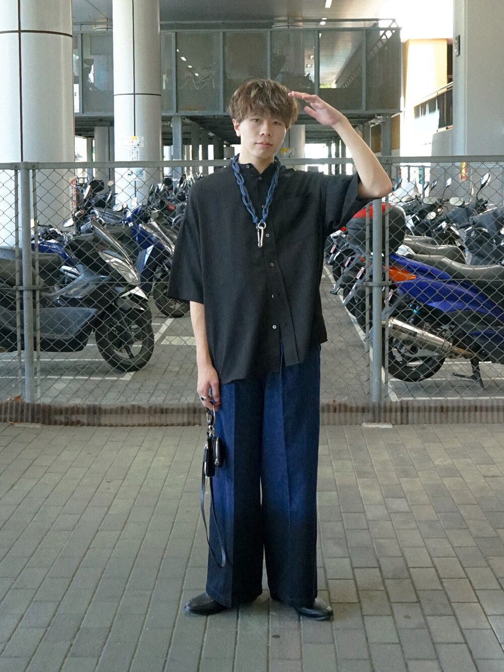 ブラック系のデニムパンツ、ブラック系のショルダーバッグ、ブルー系のウォレットチェーンを着用したメンズの夏コーディネートの2枚目の写真